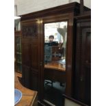 A 20th century mahogany hanging wardrobe, carved panel door with mirror, above a single drawer,