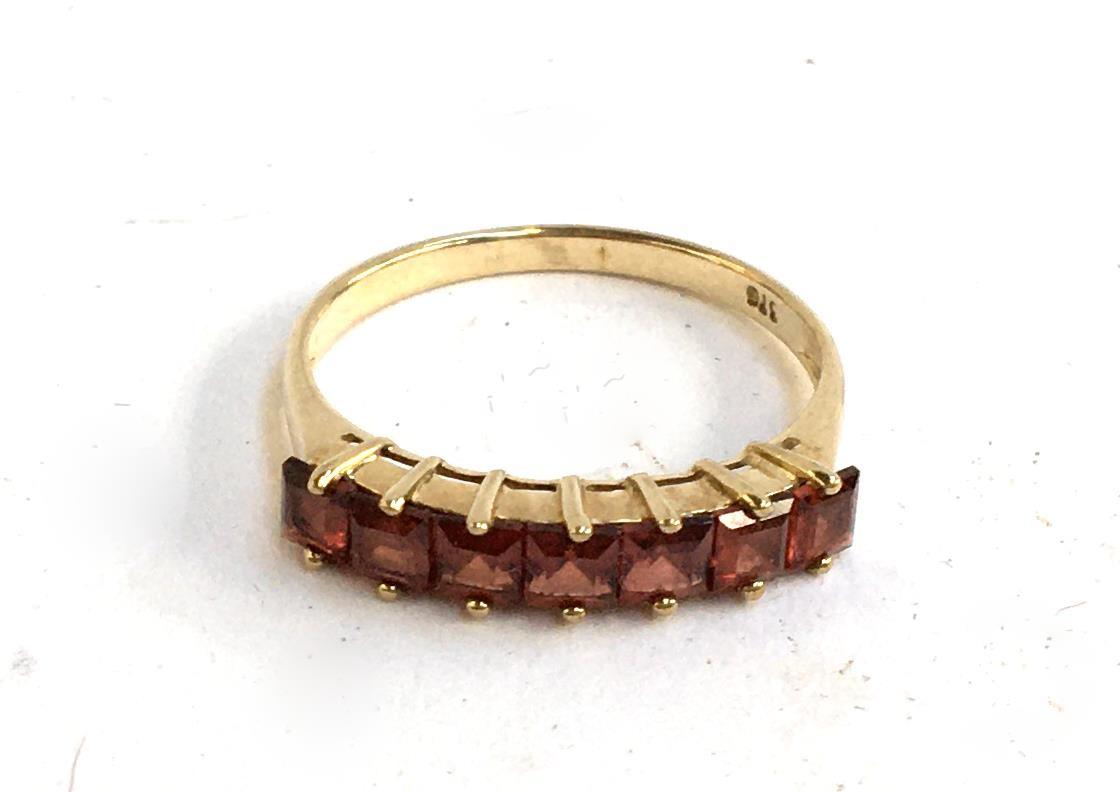 A 9ct gold ring set with seven red stones, 1.75g