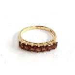 A 9ct gold ring set with seven red stones, 1.75g