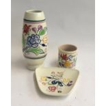 Three Poole pottery items - a vase, a rectangular dish, and a pot