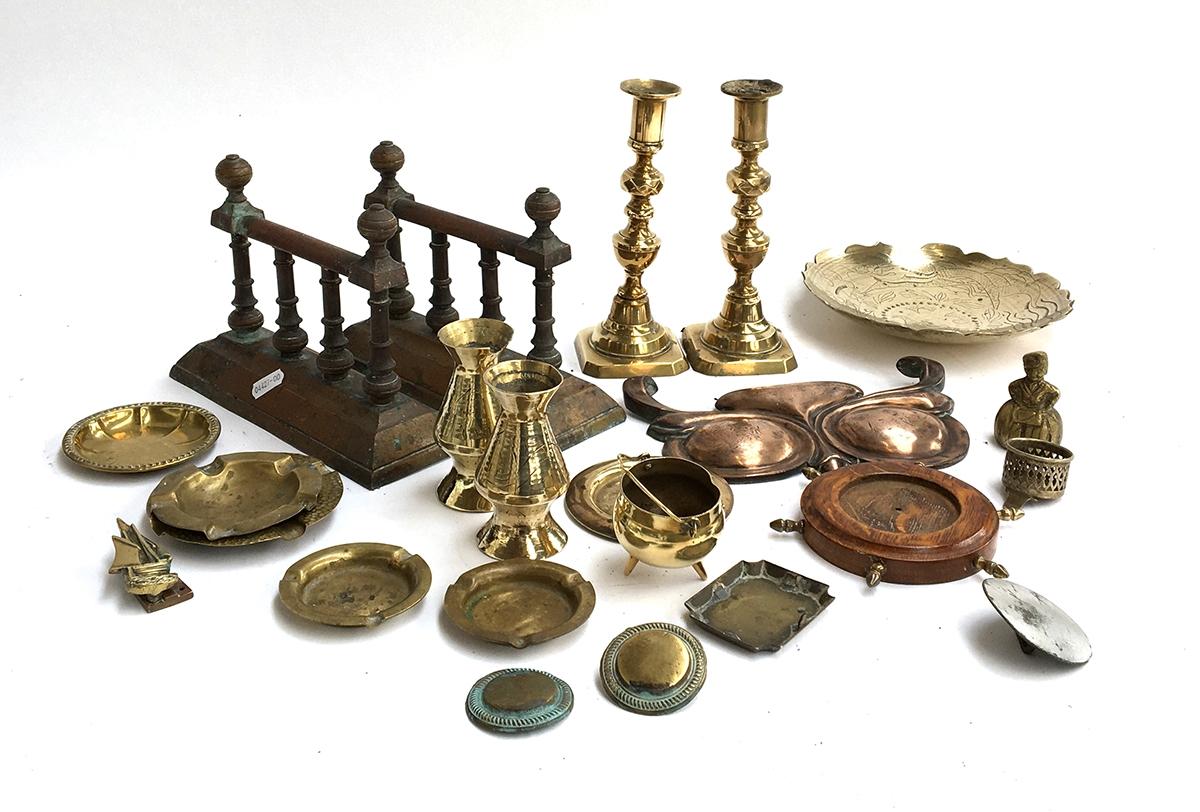 A mixed lot of brass items to include a pair of candlesticks; fire dogs; ashtrays; spill vases etc