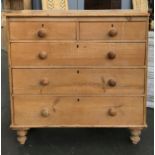 A pine chest of two short over three long drawers, turned wooden knobs, on turned feet, 103cmW