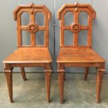 A pair of 1930s oak hall chairs, on octagonal carved front legs