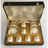 A cased set of six coffee cans and saucers by Cauldon, heightened in gilt
