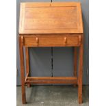 A Cotswold School oak bureau, the top with visible dove tails, above a fall front revealing pigeon