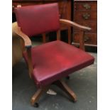 A 1950s oak and vinyl swivel desk chair, on casters