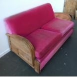 A pink upholstered 1970s two seater sofa bed