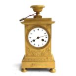 A gilt metal continental mantel clock, with urn finial, white enamelled dial, with roman numerals
