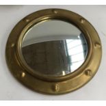 A brass porthole mirror, slightly convex plate, 27.5cmD