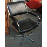 A 70s black swivel chair with chrome base and fittings