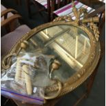 An oval giltwood and gesso wall mirror, in need of restoration, the plate 57x42cm