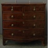 A bowfront regency mahogany and crossbanded chest of two short over three graduating drawers, with
