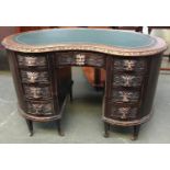 An unusual 20th century carved kidney shaped kneehole desk, with nine drawers, 115cmW