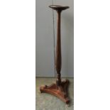 A 19th century torchere, moulded top on tapering turned column, triform base with brass pad feet,