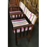 A pair of folding hardwood garden chairs with striped fabric seats