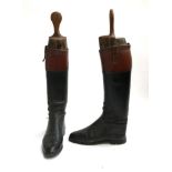 A pair of gent's black leather hunting boots with mahogany tops, and wooden trees