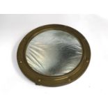 A brass 'porthole' mirror, with slightly convex plate 37cmD