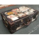 A vintage canvas suitcase, with numerous travel stickers, 69cmW