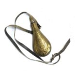 A brass powder flask, with leather strap, marked US
