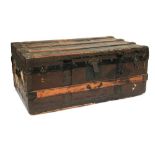 A wood banded travel trunk with metal brackets, with various travel labels, including Jerusalem,