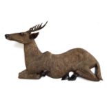 A relief carved wooden figure of a deer, 88cm long