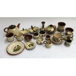 A collection of Torquay motto ware pottery, consisting of pin dishes, candlesticks, teapot, cups etc