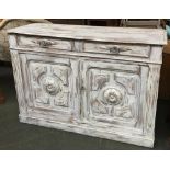 A sideboard comprising of two drawers over two cupboard doors, with applied carved decoration, the