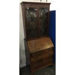 A mahogany glazed bookcase bureau, dentil cornice, astragal glazed doors over fall front with fitted