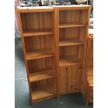 A pair of modern pine narrow bookshelves, one with cupboard door, each 43x141cmH