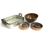 A hemispherical copper bowl, 27cmD; two donut jelly moulds; together with two heavy aluminium oven