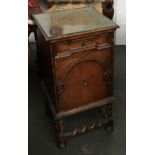A 20th century oak bedside cabinet/pot cupboard, glass inset top over single geometric drawer and