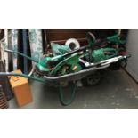 A wheelbarrow containing a large quantity of garden tools, rotovator, hedge trimmer etc; together