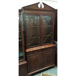 A burr walnut veneer astragal glazed bookshelf, on a base with two drawers and cupboard doors,
