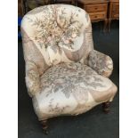 A buttonback low armchair, serpentine front on turned legs and casters