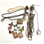 A number of beaded necklaces; together with various amulets; butterfly brooches; small vase etc