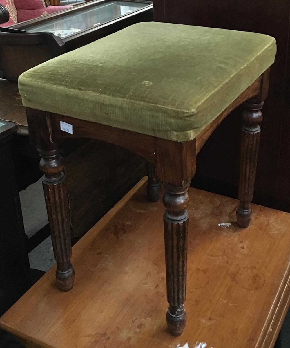 A small footstool on reeded legs