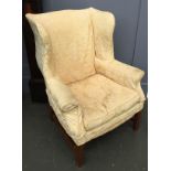 A 20th century wingback armchair, upholstered in yellow