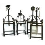 Four wrought iron and glass lanterns, each approx. 57cmH to hook (one slightly smaller)