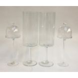 A pair of small glass domes on stemmed stands; together with a pair of tall glass vases. 40.5cmH;