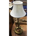 A brass table lamp with three pad feet