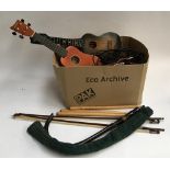 A mixed box of musical instrument accessories, mostly strings, two ukuleles; practice pipes;