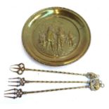 A decorative brass plate, 40cmD, together with three brass toasting forks; and a heavy brass