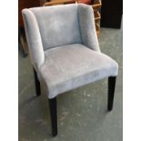 A contemporary upholstered chair with small wings on black square tapered legs