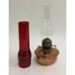 A brass oil lamp with glass chimney and non associated red glass chimney