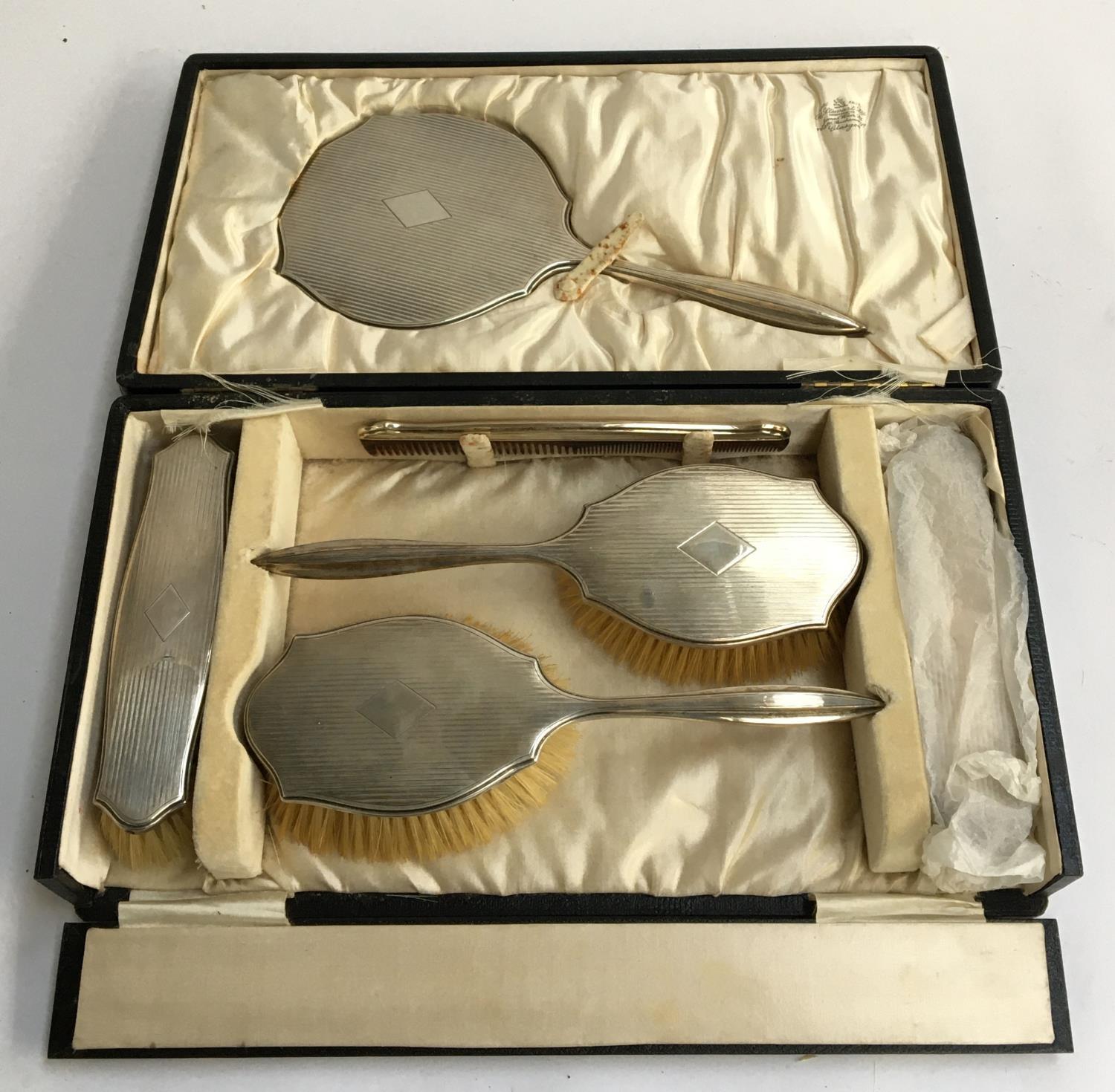 A silver vanity set comprising clothes brushes (2), hair brushes (2), vanity mirror and comb, Adie