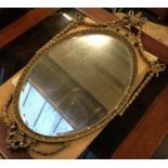 An oval wall mirror in the Adams style, bevelled plate within egg and dart molding, the top with