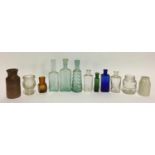 A small collection of vintage glass bottles and jars, several with glass stoppers