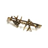 A pretty yellow metal brooch depicting swallows decorated with seed pearls