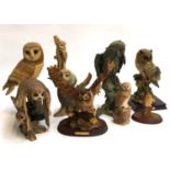 A collection of nine owl figurines of varying sizes