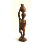 A tribal carving of a lady carrying a gourd, 31.5cmH